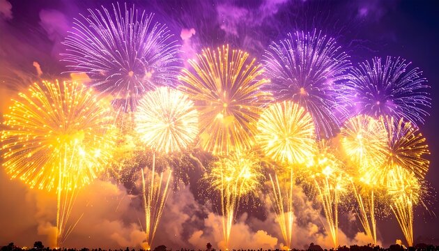 Vibrant bursts of golden and purple pyrotechnics light up the evening sky in a breathtaking fireworks display