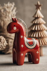 Red ceramic horse figurine with stars standing near Christmas decorations