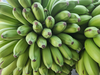 Vibrant bunch of fresh green bananas, showcasing natural texture and healthy organic produce ready for consumption or culinary use