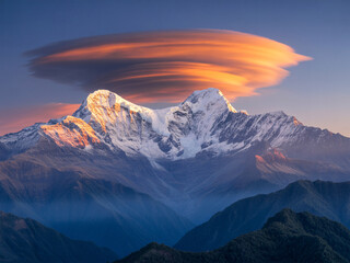 Stunning snow-capped mountain peaks bathed in golden sunrise light, crowned by a dramatic lenticular cloud formation against a clear blue sky.