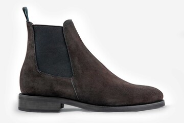 Classic leather shoes in a white background.  Dark brown suede boots.
