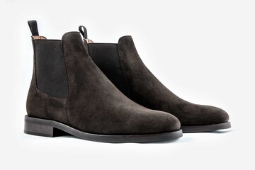 Classic leather shoes in a white background.  Dark brown suede boots.