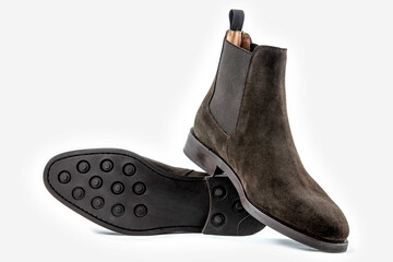 Classic leather shoes in a white background.  Dark brown suede boots.