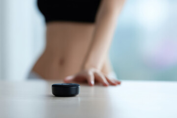 Smart home hub on table with blurred torso in background showing modern technology use
