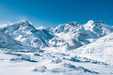 Obraz premium Majestic snow covered mountains under a clear blue sky