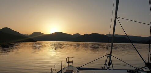 Golden Sunrise Over Mountain Range and Serene Coastal Bay Aerial Landscape