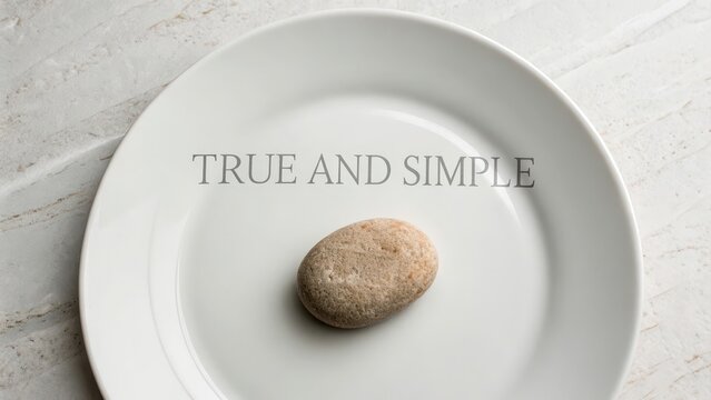 A solitary stone rests centered on a clean white plate, embodying truth and simplicity