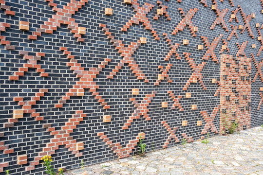 A refined architecture facade view featuring structure, repetition and geometry with strong contrast and minimalism, highlighted by a defined red frame set within pattern and detail.