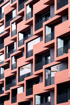 A minimal architecture facade presentation using shape, structure and pattern to create contrast, elevated by a clean red feature and flowing lines with a focus on clarity.
