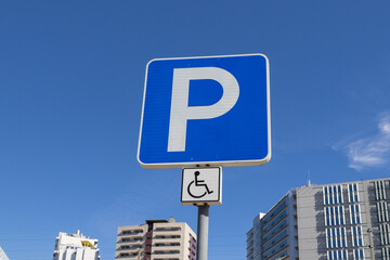 Blue parking sign with disabled accessibility symbol
