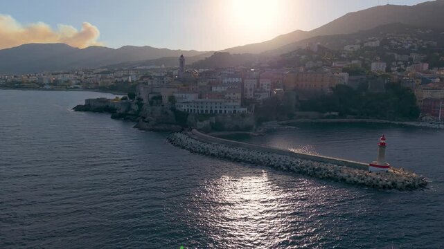 picturesque harbor during twilight hours, historic fortress overlooks tranquil water at evening. Bastia. France