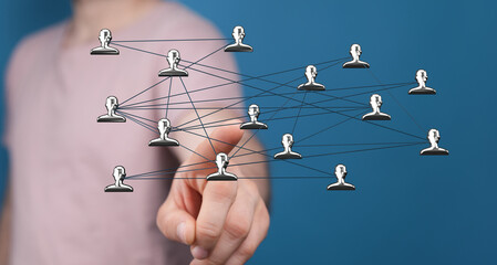 Abstract image showing network concept with a person's hand touching connected people icons representing teamwork and communication. Idea of dig