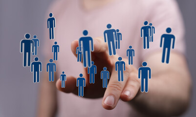 Concept of teamwork and communication in business. Hand touching floating figures representing...