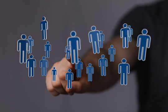 Hand pointing at floating digital people icons. Represents connectivity, networking, teamwork, and digital inte - Powered by Adobe