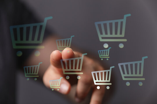 Person interacting with digital shopping cart icons, representing online shopping, sales, and the digital consumer experience. Illustrating ecom
