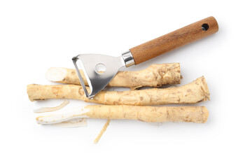 Fresh raw horseradish roots and peeler isolated on white, top view