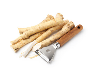 Fresh raw horseradish roots and peeler isolated on white