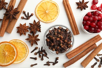 Different spices, cranberries and dry orange slices for mulled wine on white wooden table, flat lay