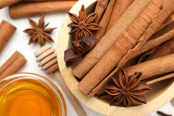 Different spices (anise, cinnamon) and honey for mulled wine on white table, top view
