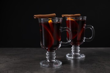 Tasty mulled wine in glass mugs on grey table, closeup