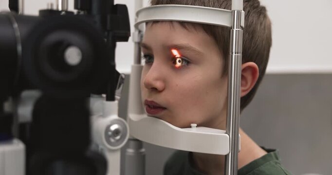 Closeup of boy having eye checkup with slit lamp microscope