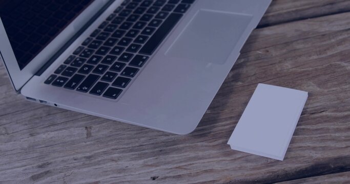 Fototapeta Showing silver laptop with keyboard, trackpad on left side of worn tabletop, with white cards