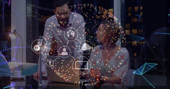 Working team in businesswear leaning over laptop, lamp, coffee in office at night, network overlay