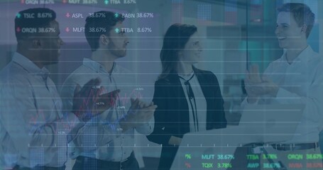 Clapping four colleagues gathering around laptop in office, in blazers, showing stock ticker charts