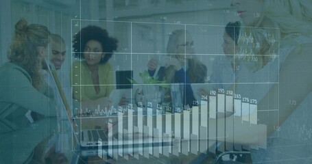 Discussing team in suits collaborating at meeting table, with laptops and charts overlay