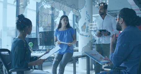 Presenting woman wearing blue top holding pages, leading team meeting in office with glass overlay