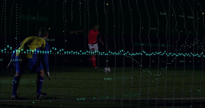 Kicking red kit player approaching soccer ball on night pitch with goal net, teal analytics overlay - Powered by Adobe
