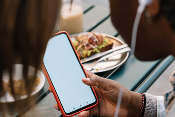 Woman using smartphone at outdoor brunch