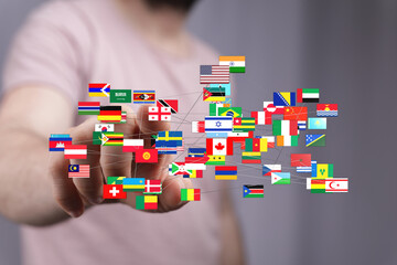 A hand pointing at an international network with world flags, symbolizing global business,...