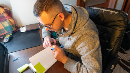 Young man writing in a notebook