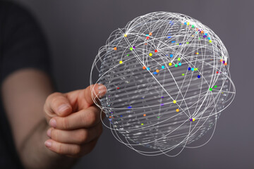 Conceptual image of a hand holding a globe overlaid with a network, symbolizing global connections, communication, and technology. Ideal for ill