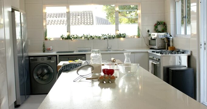 Recording starting camera holding island counter showcasing jar of flour, whisk under soft daylight
