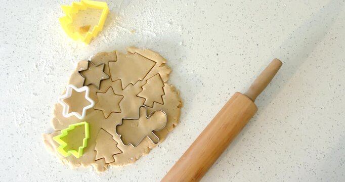 Opening shot showing cookie dough resting on speckled countertop awaiting metal and plastic cutters