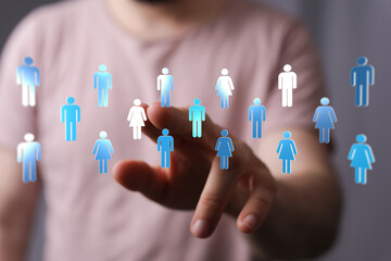 Concept of global networking, team building and digital communication. Human hand reaching towards people icons, teamwork and social media.