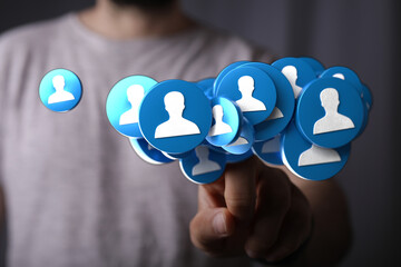 Conceptual image of social connections and teamwork. Featuring a hand touching floating user profile icons, symbolizing communication and global
