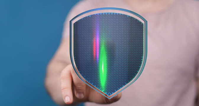 A person's hand touching a digital shield with glowing light effect, symbolizing protection and security. Perfect for cybersecurity a