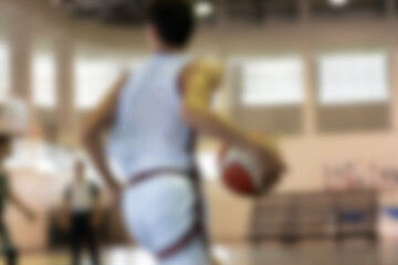 Blurred background of action shot of basketball player dribbling on court. Ball handling in arena