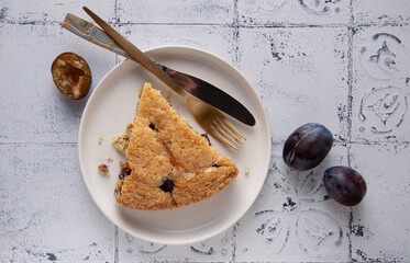 a slice of plum pie lying on a round plate, top view