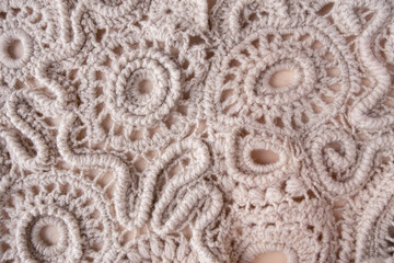Hand-knitted lace made from wool threads, textured background
