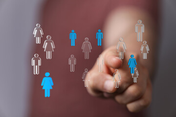 Close up shot of a hand pointing at a network of digital figures representing people. Concept of...
