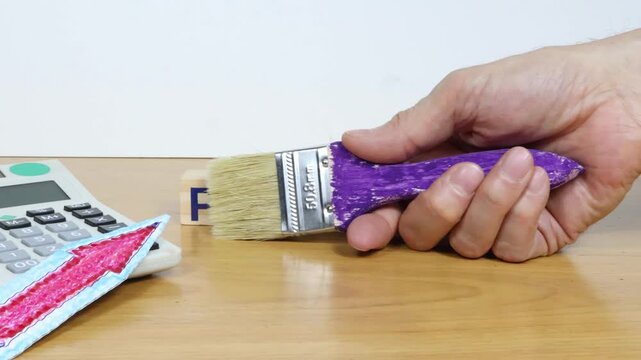 The word pension is composed of wooden blocks. A painter's brush reveals the word PENSION on the worktable.