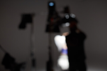 Out of focus studio with lighting and people working on the set.