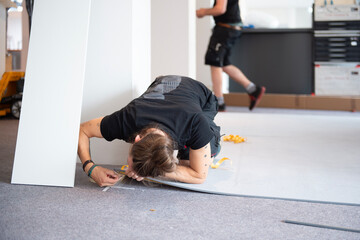 Bodenbelag exakt anpassen &ndash; Handwerker arbeitet pr&auml;zise am Randbereich