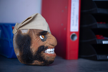 Handgeschnitzter Holzkopf mit Kopftuch als Dekoration im B&uuml;roregal