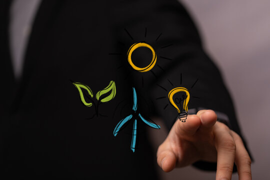 A hand interacts with digital icons representing green energy sources: sun, plant, wind turbine, and light bulb, symbolizing sustainability and