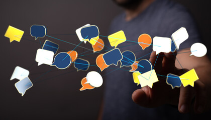 Concept of communication, technology, connection and networking. Man pointing at floating speech bubbles. Digit